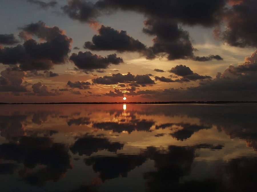 Sunset clouds mirrored in still shallow water